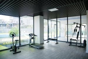 einen Fitnessraum mit mehreren Laufbändern in einem Zimmer mit Fenstern in der Unterkunft Art life apartment Flora в спальне нет окна in Alanya