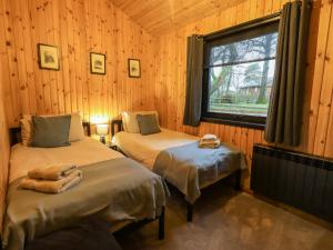 2 Betten in einem Zimmer mit Fenster in der Unterkunft Newsham Lodge in Penrith