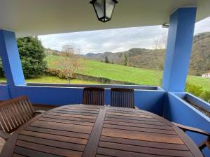 une table en bois avec deux chaises et une grande fenêtre dans l'établissement VILLA ACEBO, à Arboleya