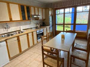 cocina con mesa, sillas, mesa y fregadero en VILLA ACEBO, en Arboleya