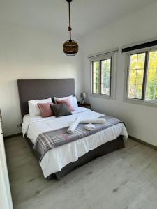 a bedroom with a large bed with pink pillows at Charming villa w/ private garden in Dubai