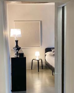 ein Schlafzimmer mit einem Bett und einem Tisch mit einer Lampe in der Unterkunft Palazzo del Papa Country Suites in Siena