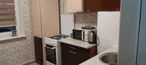 uma pequena cozinha com um micro-ondas e um lavatório em бульвар Олександрійський 137 Comfort house em Bila Tserkva