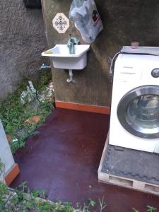 a washing machine and a sink in a yard at Pousada Sol de Primavera in Arujá