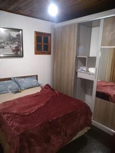 a small bedroom with a bed and a cabinet at Pousada Sol de Primavera in Arujá