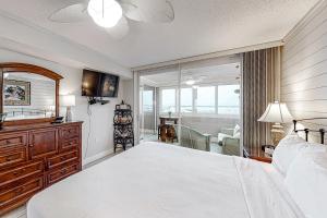 a bedroom with a large white bed and a balcony at Jetty East Condos in Destin