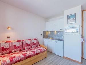 a kitchen with white cabinets and a couch in a room at Appartement La Plagne-Tarentaise, 1 pièce, 4 personnes - FR-1-351-131 in La Plagne Tarentaise