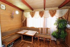a dining room with a table and chairs and a window at Садиба "Svitlana" in Yablunytsya