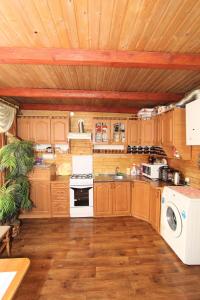 a kitchen with wooden cabinets and a stove top oven at Садиба "Svitlana" in Yablunytsya