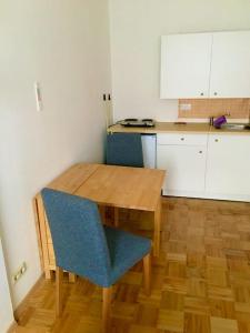 a kitchen with a wooden table and a blue chair at Ferienwohnung Struth-Helmershof in Struth-Helmershof