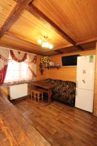 uma sala de estar com um sofá, uma mesa e um frigorífico em Садиба "Svitlana" em Yablunytsya