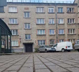 zwei Autos, die vor einem Backsteingebäude geparkt sind in der Unterkunft Cozy apartments in the center of Liepaja in Liepāja