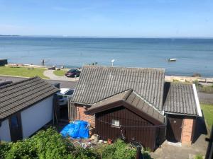 una vista aérea de una casa con el océano en el fondo en The small beach house, en Rydebäck