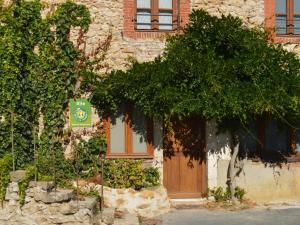 un edificio con una puerta de madera y un árbol en Gîte Le Menoux, 3 pièces, 5 personnes - FR-1-591-193, en Le Menoux