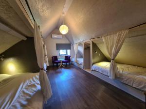 a bedroom with two beds and a table and chairs at Maison avec jardin, piscine chauffée et baignade à proximité - Le Menoux - FR-1-591-234 in Le Menoux +19 photos