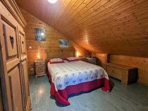 ein Schlafzimmer mit einem Bett in einer Holzhütte in der Unterkunft Gîte Cleurie, 4 pièces, 6 personnes - FR-1-589-71 in Cleurie