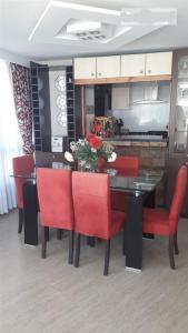 a dining room with a table and red chairs at Dpto. Frente al Mar San Martín in Viña del Mar