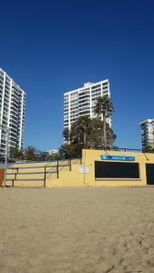 a building on the beach with buildings in the background at Dpto. Frente al Mar San Martín in Viña del Mar +25 photos