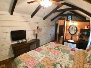 a bedroom with a bed and a flat screen tv at Cozy Cabin Near the Smokies #12 Carlotta in Sevierville +11 photos
