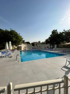 una gran piscina con sillas alrededor en Charming villa w/ private garden en Dubái