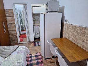 eine Küche mit einem Kühlschrank und einem Tisch sowie ein Esszimmer in der Unterkunft Cantinho da Paz in Niterói