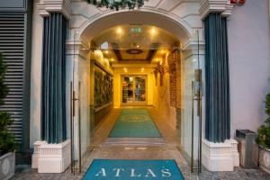 an entrance to an atlas store with green columns at ATLAS Hotel in Timişoara