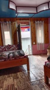 a bedroom with a bed in a room with wooden walls at Eden Homestay Sittong in Kurseong