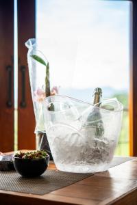 einen Tisch mit einer Schüssel Wasser und einer Vase in der Unterkunft Vertentes da Mantiqueira in Santo Antônio do Pinhal