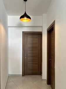 um corredor com duas portas de madeira e uma luz em Angani Apartment em Mombasa