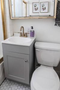 W łazience znajduje się umywalka, toaleta i lustro. w obiekcie Wyndams Foresight Quaint Abode Near Everything w mieście Tulsa