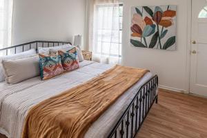 a bedroom with a large bed with pillows on it at Wyndams Foresight Quaint Abode Near Everything in Tulsa