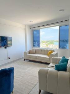 una sala de estar con 2 sofás blancos y una ventana grande en Angani Apartment, AC Installed, Ocean View & Rooftop Pool, en Mombasa