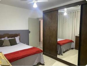a bedroom with two beds and a large mirror at Apartamento aconchegante com 03 quartos ideal para familia ou turma in Diamantina