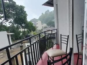 a balcony with chairs and a view of a building at Days Inn B/B in Kandy