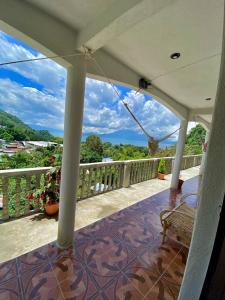 eine Veranda mit einer Bank auf dem Balkon in der Unterkunft Hotel Berena in San Marcos La Laguna