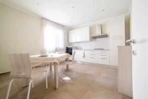 a kitchen with a table and chairs in a room at Home by Massi in Lido di Camaiore
