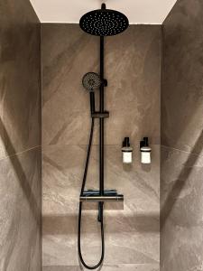 La salle de bains est pourvue d'une douche avec un pommeau de douche. dans l'établissement Le Nid de l'Aiguille - Au pied de l'Aiguille du midi, à Chamonix-Mont-Blanc
