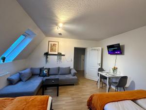 a living room with a blue couch and a table at Modern Apartment in Gütersloh Avenwedde in Gütersloh