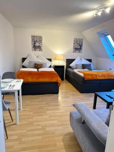um quarto com duas camas, uma mesa e um sofá em Modern Apartment in Gütersloh Avenwedde em Gütersloh