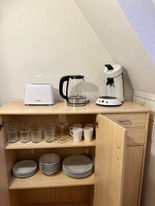 a shelf with plates and a coffee maker on it at Modern Apartment in Gütersloh Avenwedde in Gütersloh
