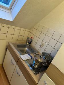 uma cozinha com um lavatório e um fogão com panelas e frigideiras em Modern Apartment in Gütersloh Avenwedde em Gütersloh