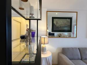 un soggiorno con tavolo in vetro e divano di Luxury Posillipo Capri View Apartment a Napoli