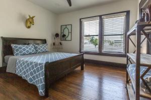een slaapkamer met een bed en een houten vloer bij Bison Flat - Redefined Urban Luxury in Tulsa