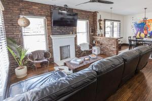 a living room with a leather couch and a fireplace at Bison Flat - Redefined Urban Luxury in Tulsa