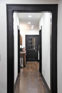 a hallway leading to a kitchen with a black door at Bison Flat - Redefined Urban Luxury in Tulsa