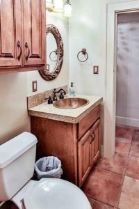 uma casa de banho com um lavatório, um WC e um espelho. em The Teak Follow, beautiful brick enclosed space em Tulsa