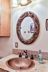 een wastafel in de badkamer met een grote spiegel aan de muur bij The Teak Follow, beautiful brick enclosed space in Tulsa