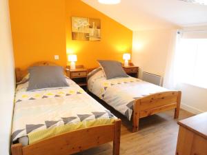 2 camas en una habitación con paredes amarillas en Gîte Chemillé-en-Anjou-Chemillé-Melay, 4 pièces, 6 personnes - FR-1-622-2 en Saint-Georges-du-Puy-de-la-Garde