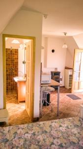 ein Wohnzimmer mit einem Tisch und einer Küche in der Unterkunft Hegyestű Apartman in Monoszló
