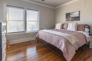 a bedroom with a bed and two windows at The T-town Yorkshire Flat in Tulsa